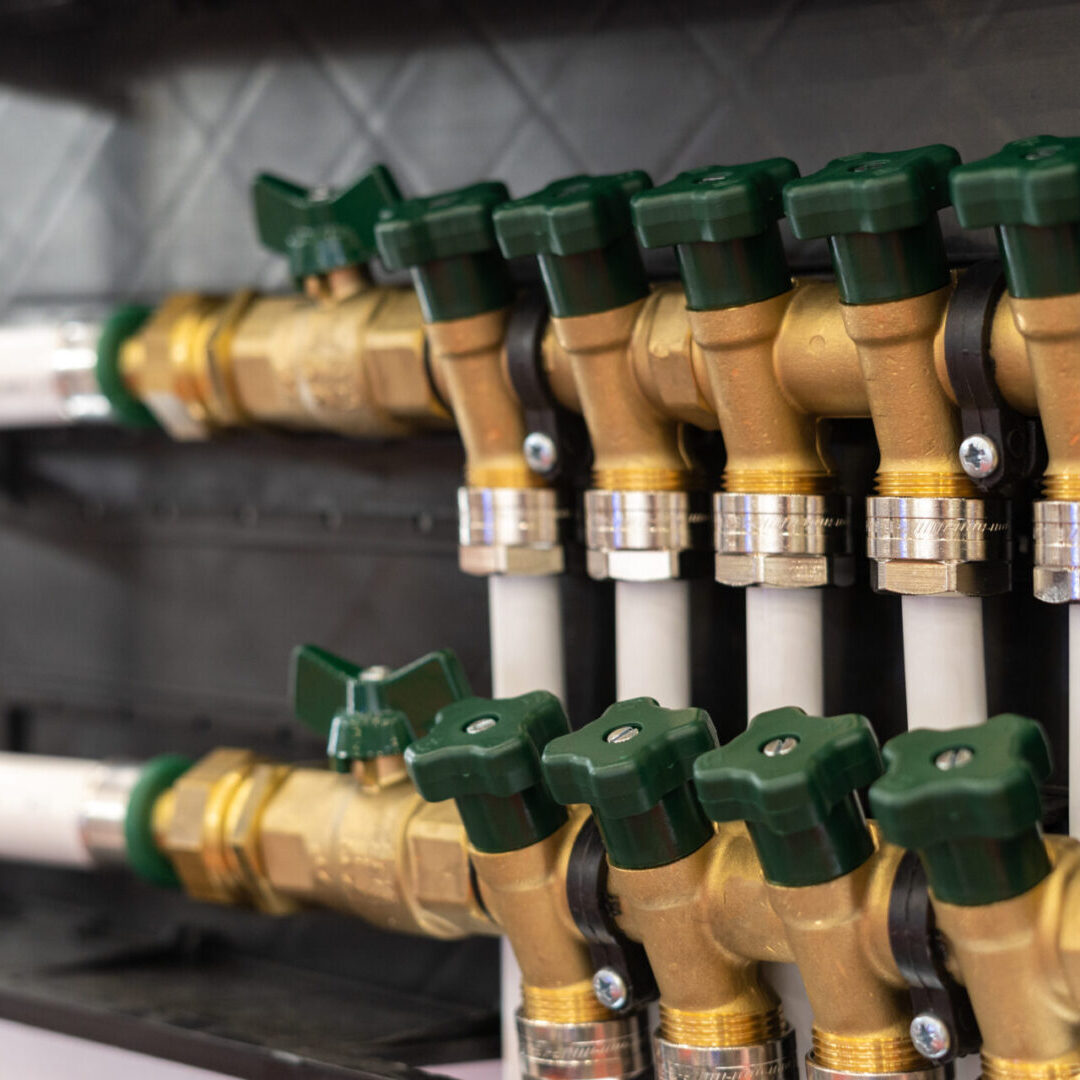 Brass plumbing valves with green handles.